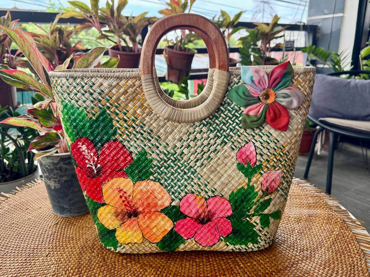 Handwoven bayong tote with vibrant hand-painted red and yellow hibiscus flowers