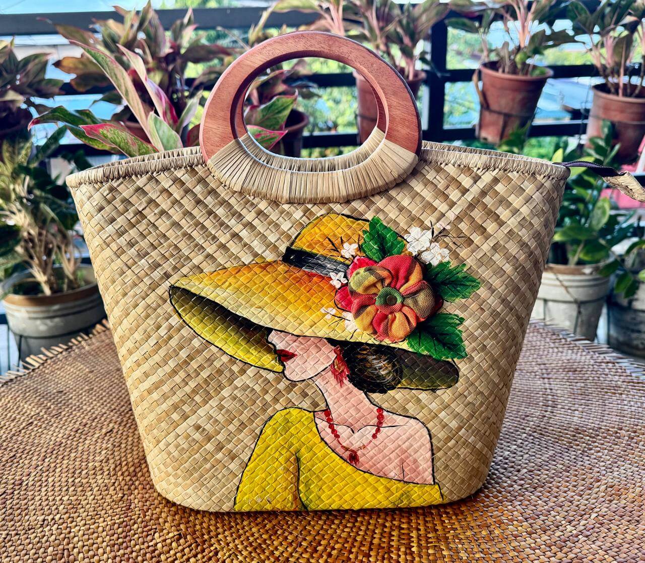 Hand-painted portrait tote featuring a woman in a golden yellow sunhat with red necklace and floral accents